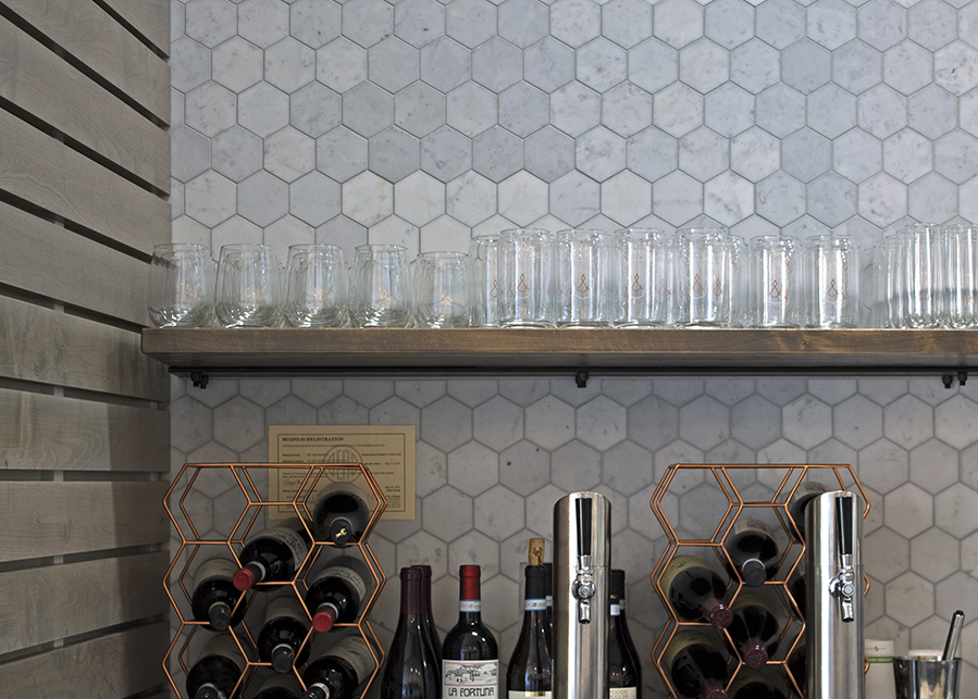A closeup of the marble honeycomb-style tiles used for the backsplash, the shape is repeated in the copper wine holders